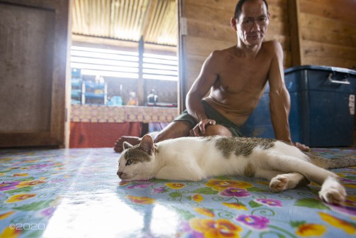 Im Hintergrund ein Penan und sein liebgewonnenes Haustier.